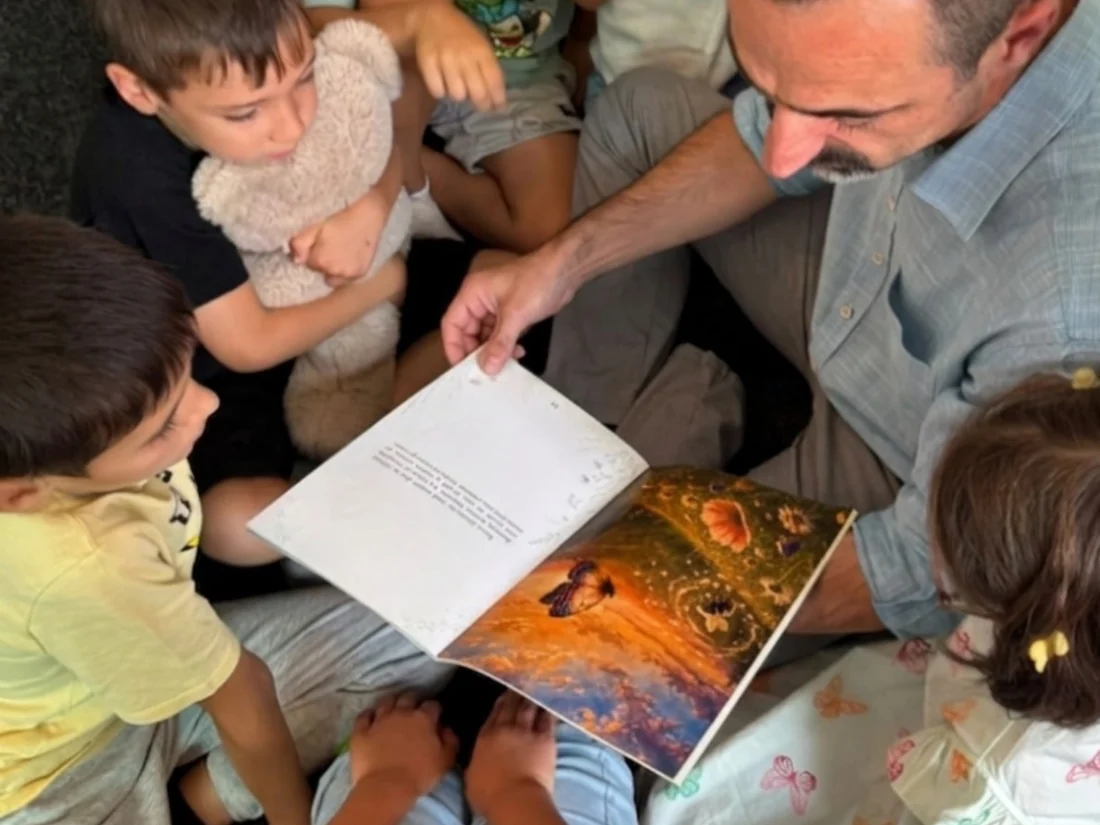 Copii adunați în jurul cărții ilustrate