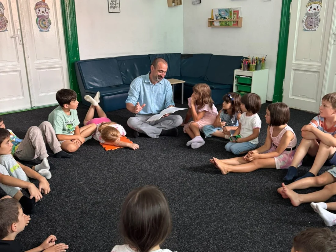 Nicu Bujor citind cartea unui grup de copii